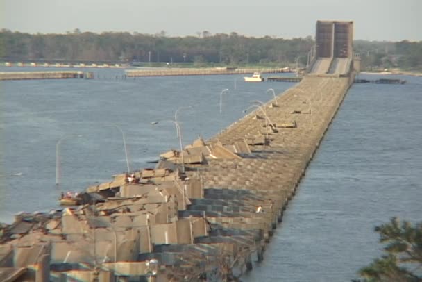 Water flows around a destroyed causeway — Stock Video