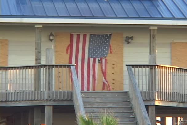 Bordade upp huset med en trasig amerikanska flaggan efter orkanen Katrina. — Stockvideo