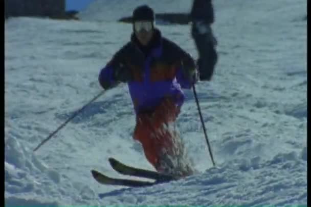 Skiërs skiën beneden en springen — Stockvideo