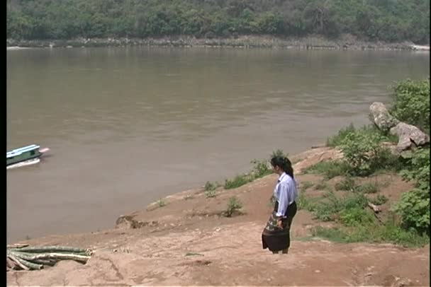 Женщина идет вдоль береговой линии — стоковое видео