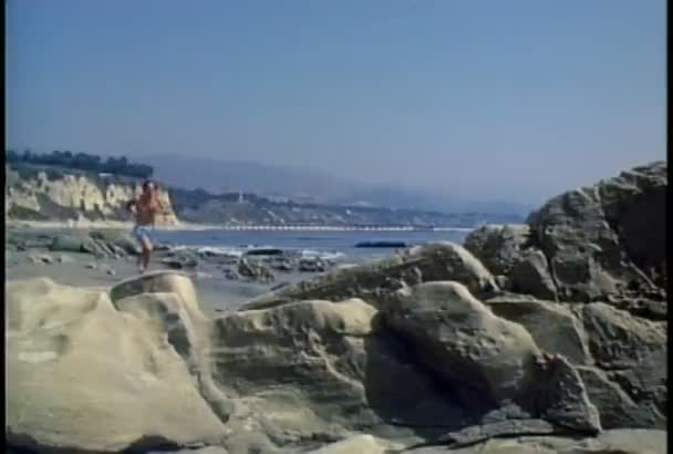 Man lopen langs een strand — Stockvideo