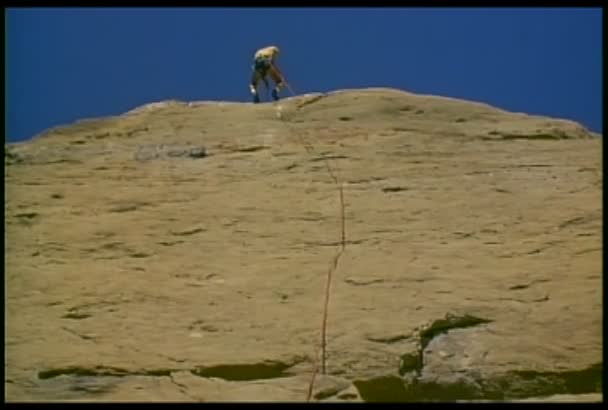 Hombre rappel abajo de una montaña — Vídeos de Stock