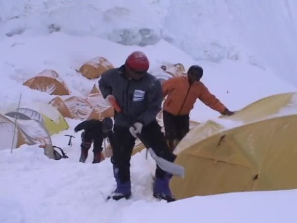 Bergsteiger schaufelt Schnee aus Zelt — Stockvideo