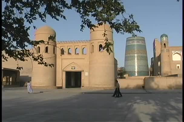 Mensen lopen in de ommuurde stad van Khiva — Stockvideo