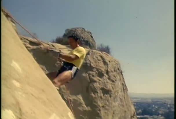 Homem rappels para baixo uma montanha — Vídeo de Stock