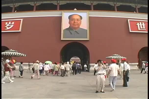 Ludzie chodzą pod portret Mao Zedonga — Wideo stockowe