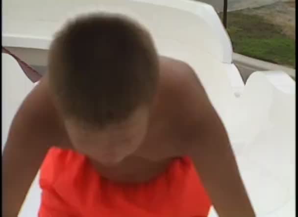 Boy goes down a water slide — Stock Video