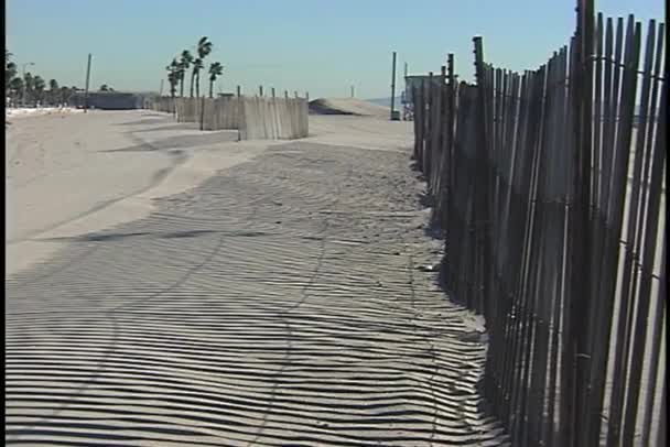 Cerca lança sombras na praia — Vídeo de Stock