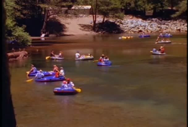 Gyerekek lovagolni gumibelsőkön folyó — Stock videók