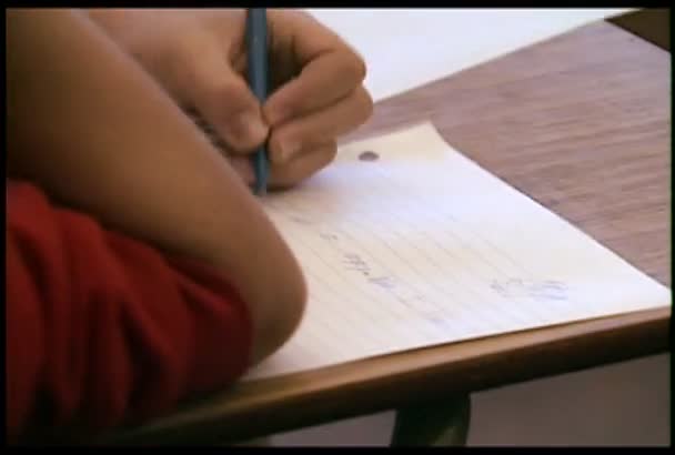 Estudiante escribe en una hoja de papel — Vídeo de stock