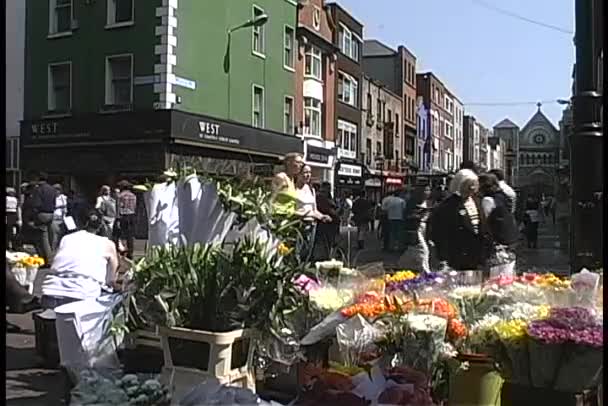 Shoppers passeren een bloem staan in Dublin — Stockvideo