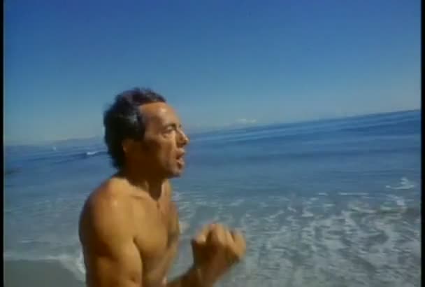 Człowiek biega wzdłuż plaży — Wideo stockowe
