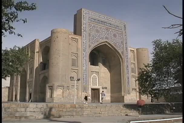 La gente camina frente a una mezquita — Vídeos de Stock