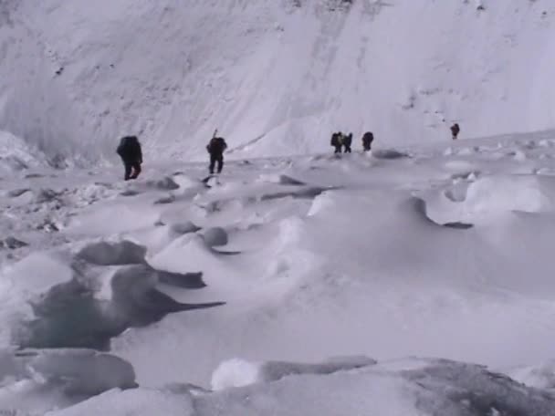 Escaladores caminan a través de un campo de nieve — Vídeos de Stock