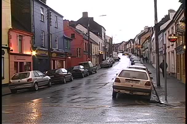 Bedrijven langs een regenachtige straat in Dingle — Stockvideo