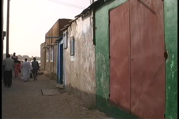 Pessoas andando por um beco em uma favela — Vídeo de Stock