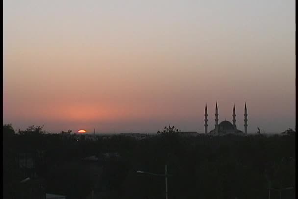 Mezquita y minarete siluetas contra el cielo — Vídeo de stock
