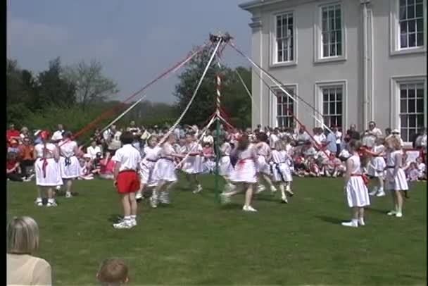 Kinderen dansen rond een kleurrijke Maypole — Stockvideo