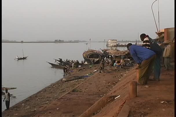 Longboats en mensen langs de oevers — Stockvideo