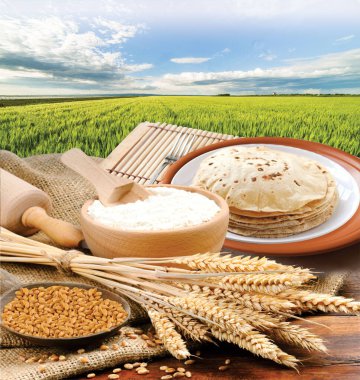 Etrafı malzemelerle çevrili bir tabak chapati 'nin Rustik görüntüsü.