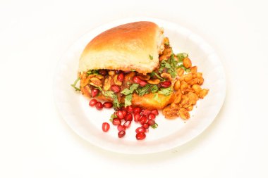 Dabeli, beyaz seramik tabakta nar tohumu ve Cilantro ile servis edilen bir Hint atıştırmalığı. Yeşil turşulu ve demirhindi soslu..