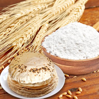 Etrafı malzemelerle çevrili bir tabak chapati 'nin Rustik görüntüsü.