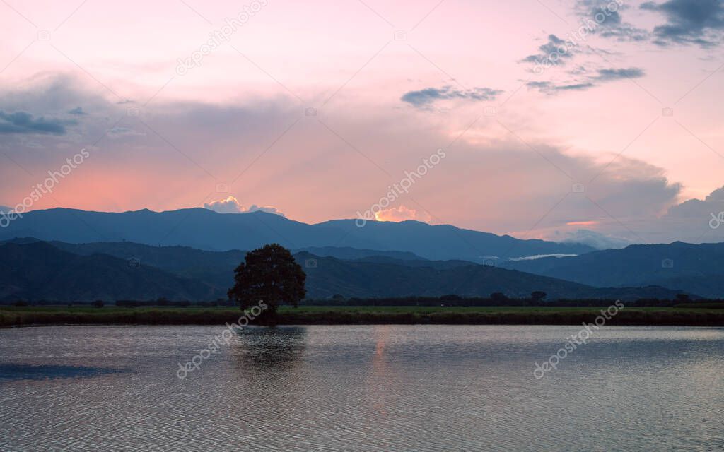 Image of a sunset, with a lake and colored sky in Valle del Cauca, Colombia.