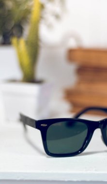 Masanın üzerinde beyaz bulanık bir arka planı olan güneş gözlüğü. Ofis işi.