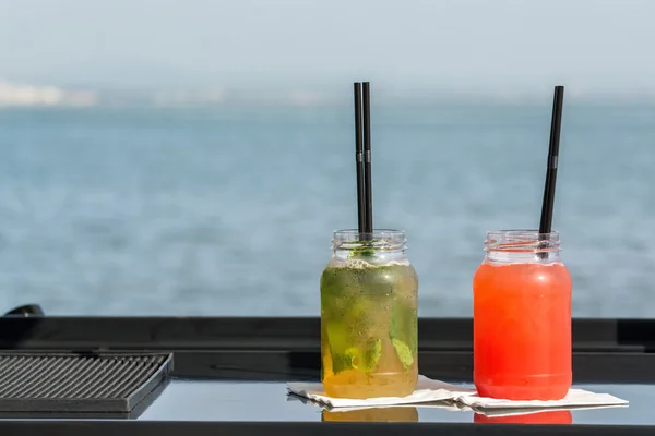 Два коктейлі перед водою — стокове фото