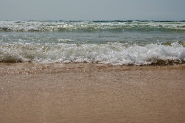 Okyanus dalgaları kumsalda kırılıyor