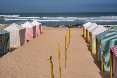 Torres Vedras Portekiz 'de Santa Cruz plajında farklı renklerde tekstil kumsal çadırları..