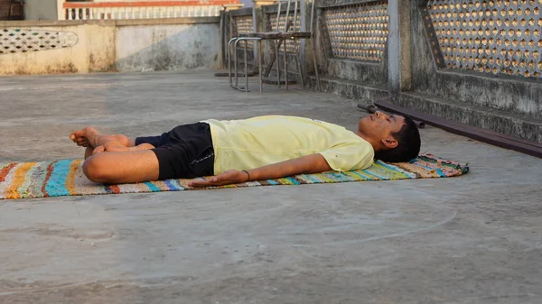 young man doing yoga in the morning at roof.