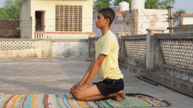 Genç adam sabahları yoga yapıyor..