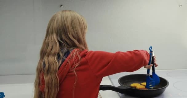 Девушка готовит еду на кухне — стоковое видео