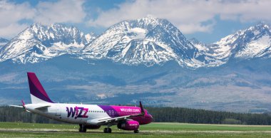 Poprad, Slovakya - 03 Mayıs 2015: Wizz air uçak Poprad Havaalanı kalkışa hazır. Yüksek Tatra Dağları'nın görünümü