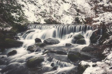 Karpat dağlarındaki güzel Shypit şelalesinin manzarası, kış manzarası. Popüler turistik etkinlik, duvar kağıdı veya kapak için uygun doğa seyahati arka planı