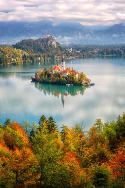 Slovenya 'daki ünlü Alp Bled Gölü (Blejsko jezero), muhteşem sonbahar manzarası. Göl manzaralı, kiliseli ada, Mala Osojnica 'dan Kanlı Kale ve Julian Alps, dikey seyahat geçmişi
