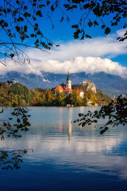 Slovenya 'daki ünlü Alp Bled Gölü (Blejsko jezero), muhteşem sonbahar manzarası. Göl manzaralı, kiliseli ada, Kanlı kale, dağlar ve bulutlu mavi gökyüzü, açık hava seyahati