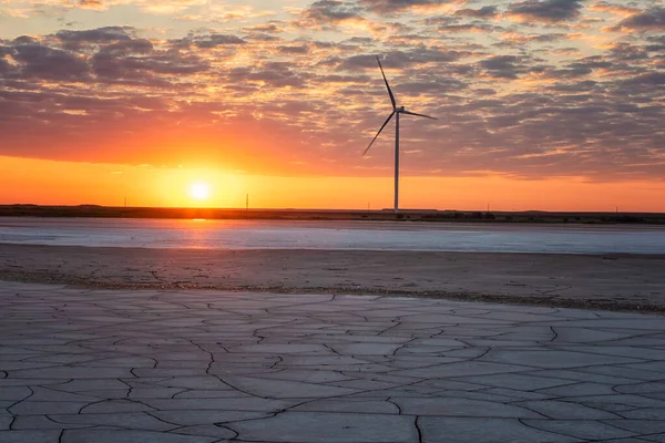 夕阳西瓦什湖和风电场背景极端咸咸的日落 Kherson地区乌克兰地貌景观 地表奇形怪状 地面和水裂缝 — 图库照片