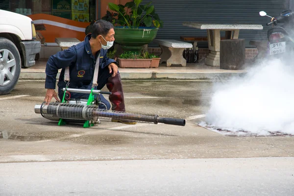 Un hombre empañando mosquitos para prevenir el dengue Imágenes De Stock Sin Royalties Gratis