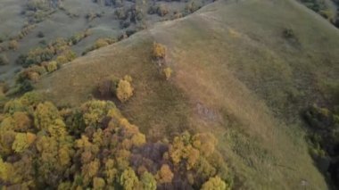 Sonbaharda orman ve çalılarla kaplı dağların üzerinden uç. Drone görünümü