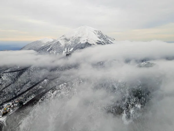 Landscape of a mountain peak in snow and fog. Higher than clouds. Drone frame. Mountain Beshtay, Pyatigorsk,Russia
