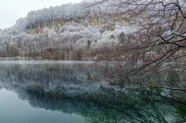 Fabulous view with reflection of trees in a lake with crystal clear blue water. Location Blue Lake, Kabardino-Balkaria. North Caucasus, Russia