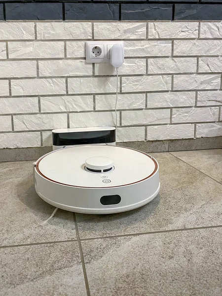 Robot elektrik süpürgesi şarj edildikten sonra yükleme limanında. Akıllı ev.