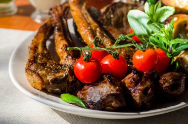Taze, ev yapımı et şişleri, sebze ve baharatlı, barbekü soslu ve ketçaplı, yakın plan beyaz bir tabakta.