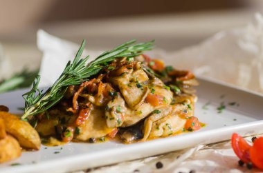 Mantar soslu tavuk göğsü ve masada patates kızartması..