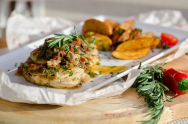 Mantar soslu tavuk göğsü ve masada patates kızartması..