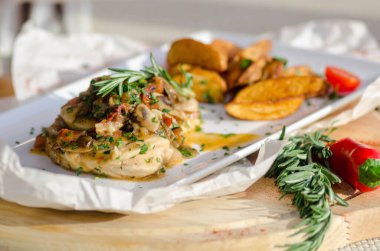 Mantar soslu tavuk göğsü ve masada patates kızartması..