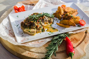 Mantar soslu tavuk göğsü ve masada patates kızartması..