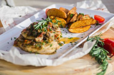 Mantar soslu tavuk göğsü ve masada patates kızartması..